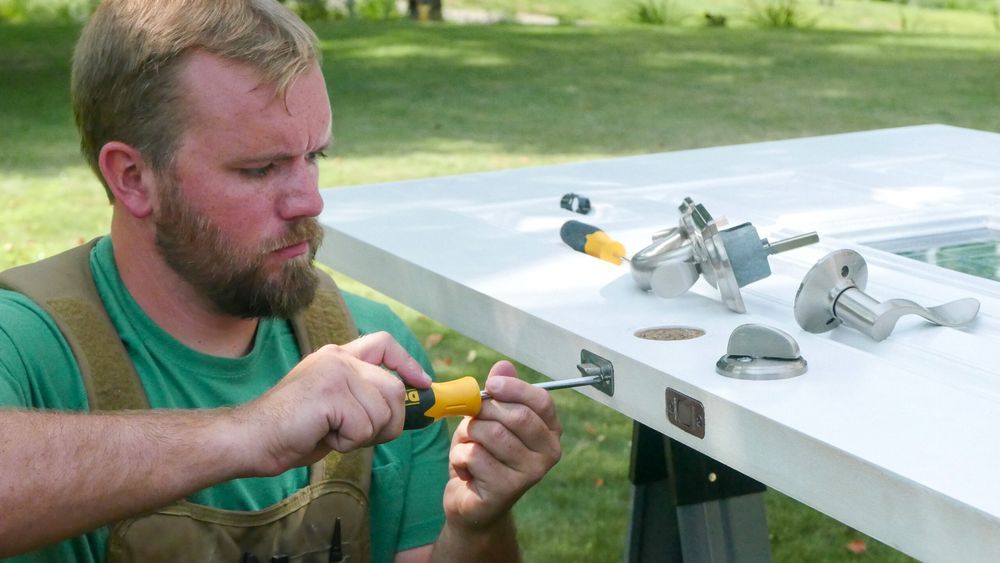 Nathan Gilbert adjusting the hardware on a front door.