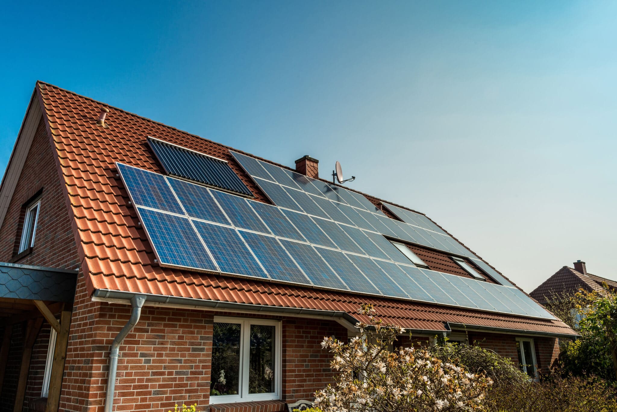 A red brick house with solar panels on the roof.